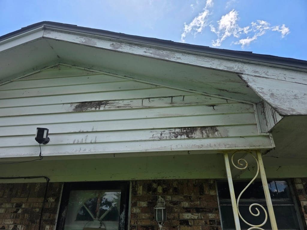 Dirty, mildew-streaked gable siding before a house wash